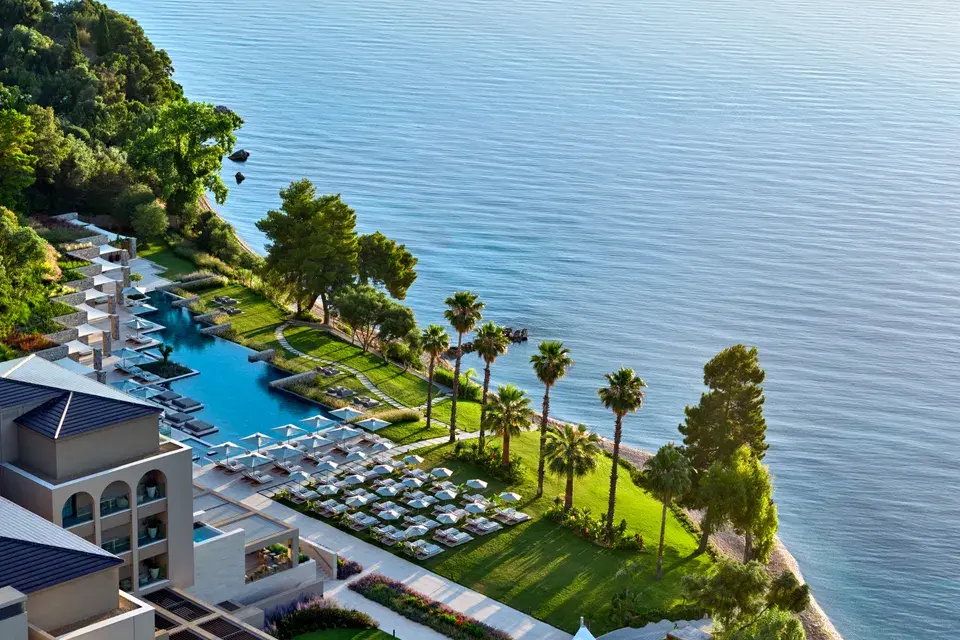 Avali in Corfu with an outdoor pool, palm trees, and views of the Ionian Sea.