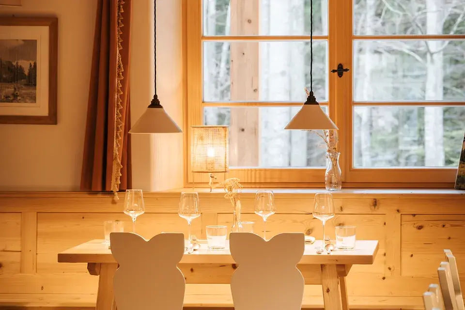 A set dining table in the wood-paneled dining room of the Chiemsee Chalet.