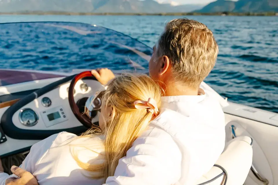 A couple rides together in a motorboat on Lake Chiemsee.