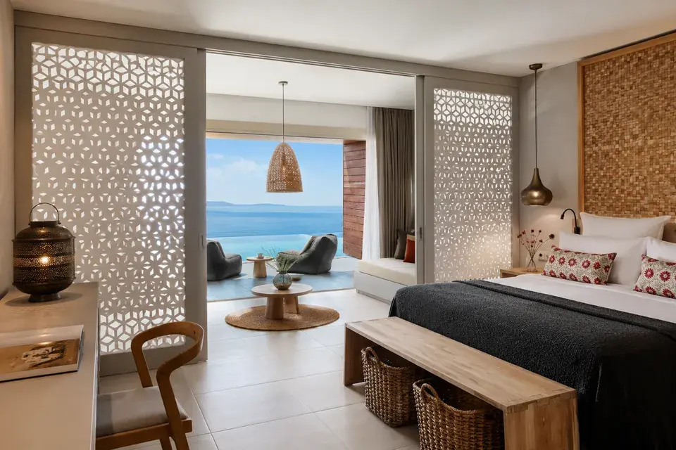 Elix - Family Room Swim Up - A bright, open-concept room with seating and a terrace featuring a pool and ocean views