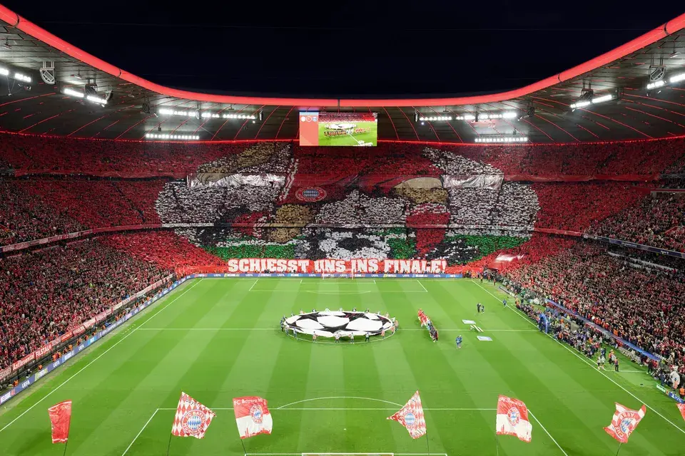 Blick auf das Spielfeld der Allianz Arena und die Fan-Choreografie in der Fankurve und Fahnen auf dem Spielfeld
