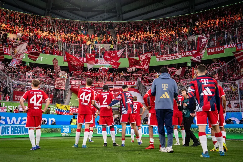 Spieler des FC Bayern München bedanken sich in der Fankurve bei den Heimfans im Stadion in Wolfsburg