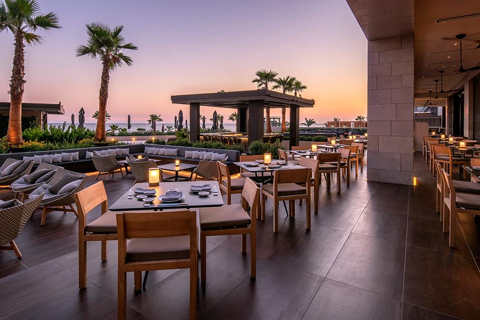 Restaurant Matsuhisa Außenterrasse in Abenddämmerung mit Blick auf Palmen, Gartenanlage und Meer