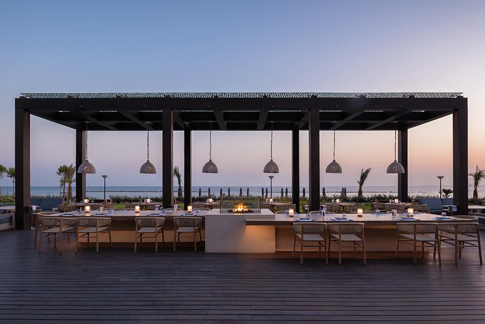 Nerea Restaurantterrasse des AMARA mit gedeckten Tischen, Sitzbereichen und Palmen bei Sonnenuntergang