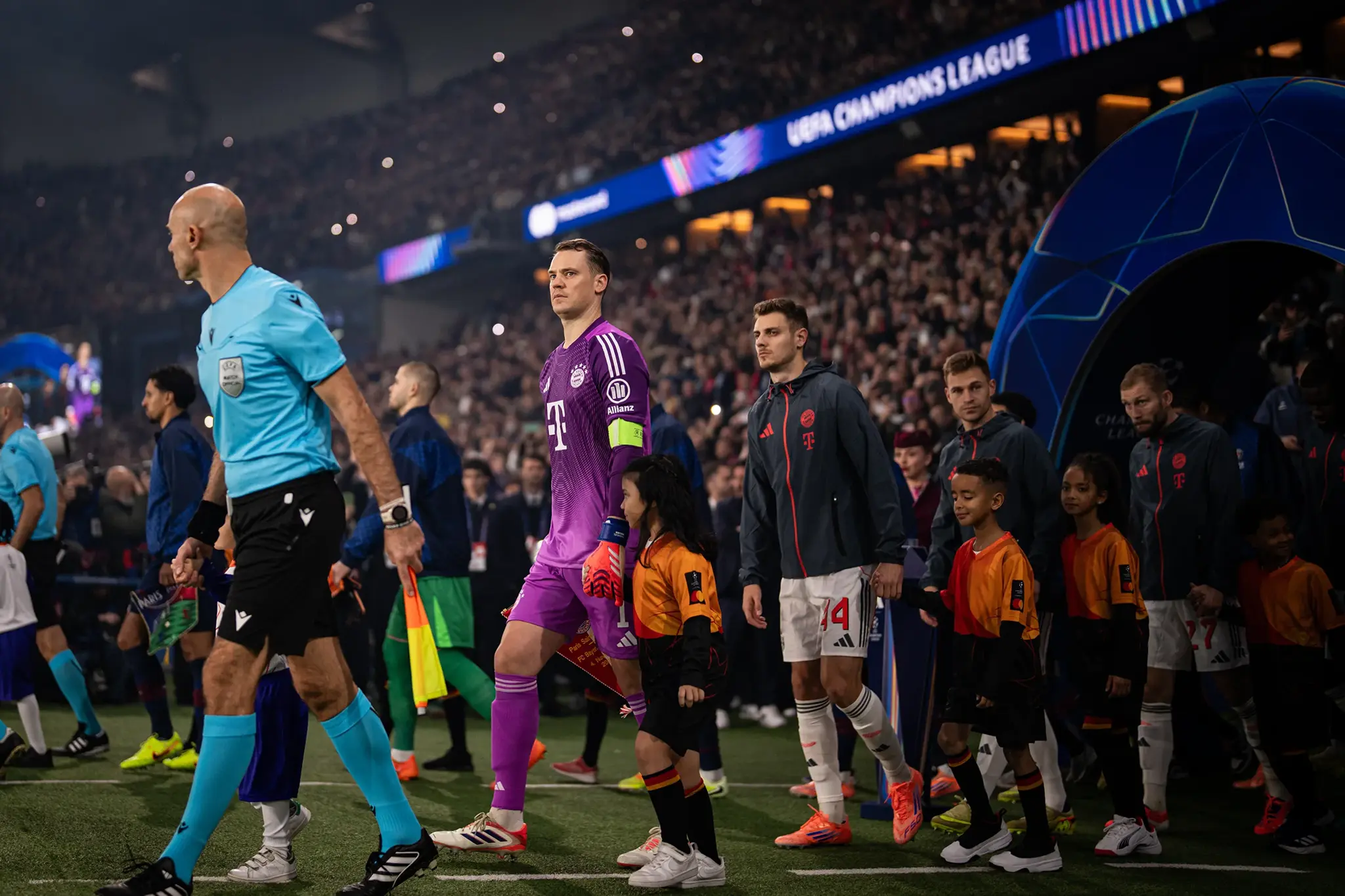 Manuel Neuer führt die Spieler des FC Bayern München im Stade de France mit Einlaufkindern auf das Spielfeld, hinter dem vorausgehenden Schiedsrichtergespann.