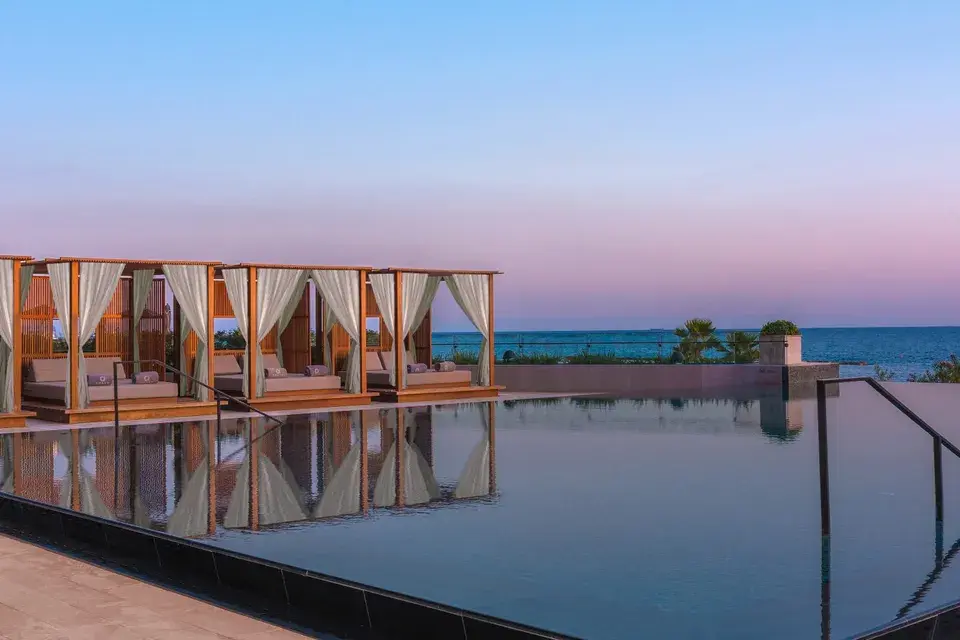 Salzwasser-Infinity-Außenpool mit Day Beds im Sonnenuntergang