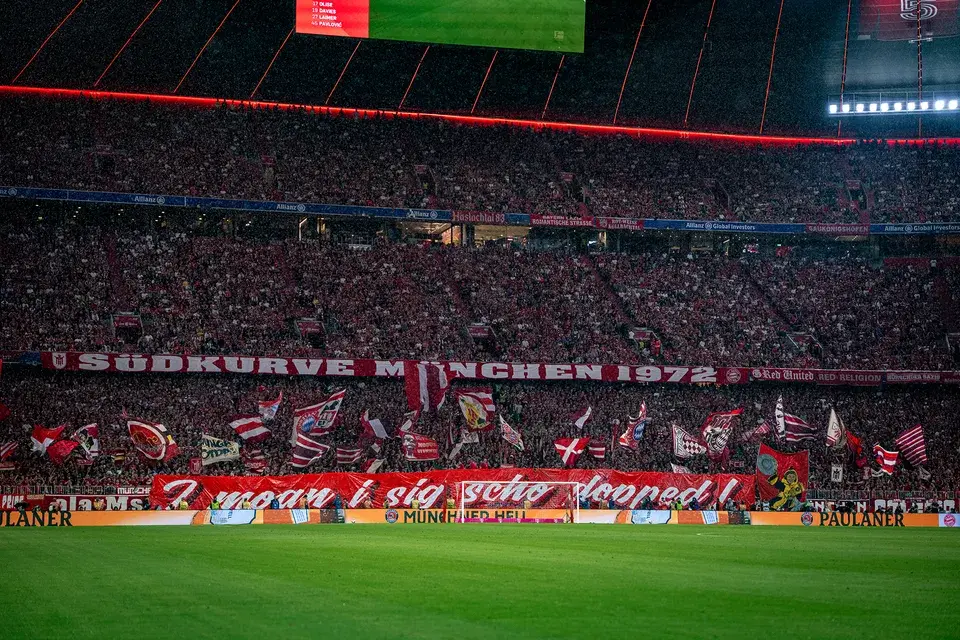 Allianz Arena Blick vom Spielfeld auf die jubelnden Fans in der Südkurve