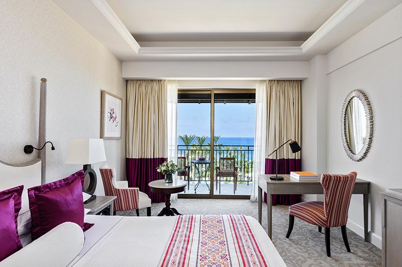 Deluxe Bedroom at Elysium with a double bed, sitting area, and balcony with a view of the sea