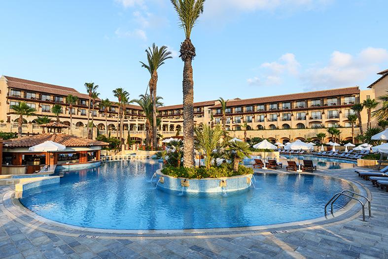 Mare Nostrum, the Elysium's outdoor pool, with palm trees, sun decks, and the hotel building in the background