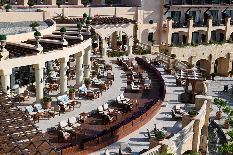 Hotel terrace with columns and lounge chairs in the sunshine