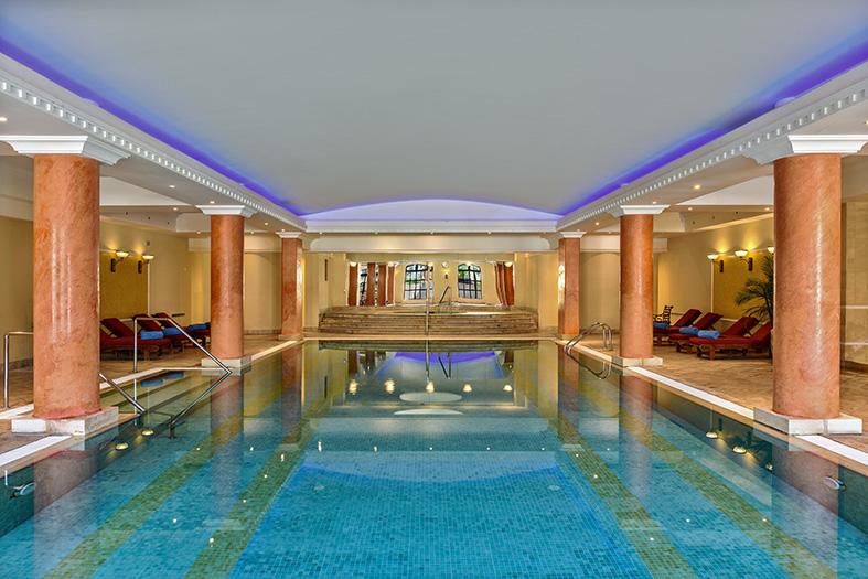 Indoor pool at the Elysium’s Opium Health Spa with columns and lounge areas